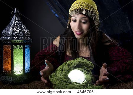 Woman dressed in a Halloween costume looking into a crystal ball