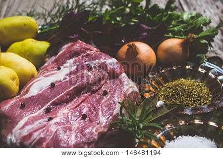 Raw meat and vegetables on woodden background