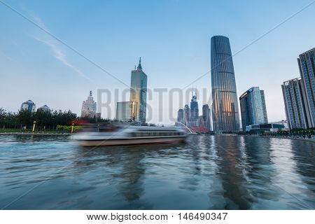 a pleasure boat motion blur on the beautiful haihe river in tianjin central business district at dusk China