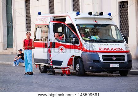Rome, Italy - August, 7, 2016: team of doctors near the ambulance car on Piazza Navona in Rome. Italy