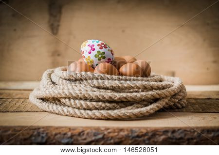 Easter eggs in a basket made from rope on a wooden table