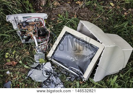 broken white computer lying on the grass