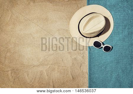 Top view of sandy beach with summer accessories and copy space around products. Blank mock up for advertising or packaging.