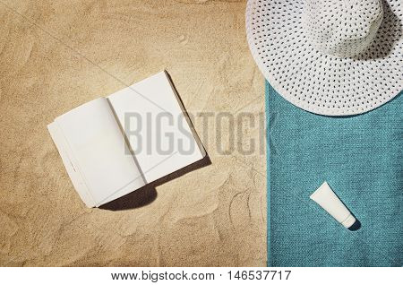 Top view of sandy beach with summer accessories and copy space around products. Blank mock up for advertising or packaging.