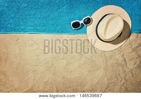 Top view of sandy beach with summer accessories and copy space around products. Blank mock up for advertising or packaging.