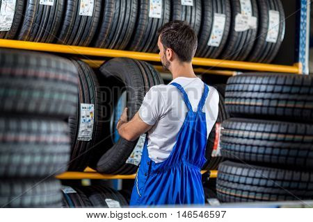 Mechanic sale a new tire for car at a tire store 