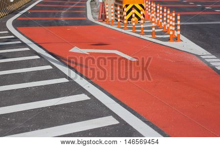 traffic arrow signage on red road outdoors