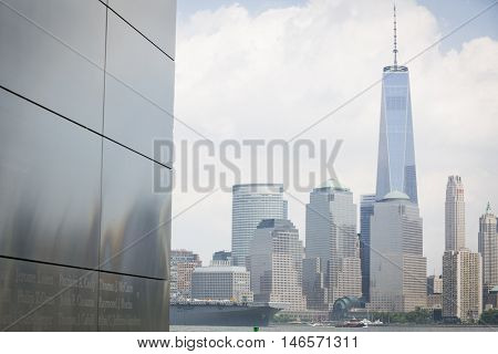 JERSEY CITY NJ - MAY 31 2016: USS Bataan (LHD 5) passes the Empty Sky Memorial and the Freedom Tower upon departing Manhattan marking the end of Fleet Week 2016 as seen from Liberty State Park.