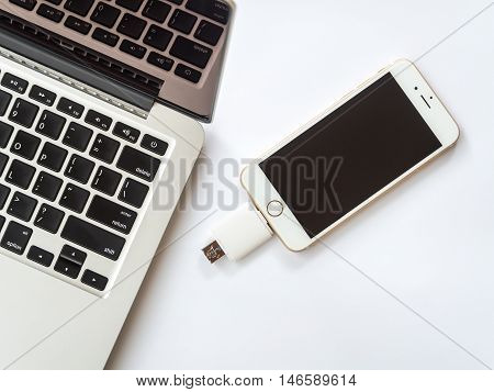 CHINGRAI THAILAND -SEPTEMBER 7 2016: Top view image of two way external flash storage transfering data with Apple iPhone 6 and close to Apple Macbook Pro Retina on white background