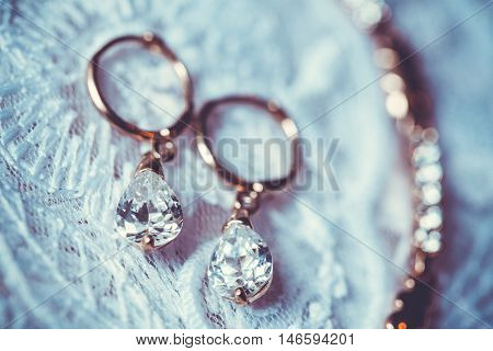 Fine jewelry: earrings on the white wedding dress