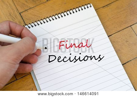 White notepad and human hand on the wooden background