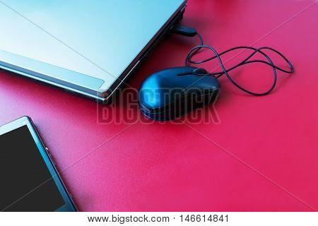 laptop mouse mobile phone on red table