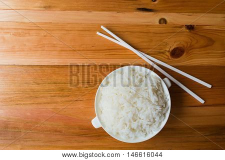 A steam rice in ceramic cup on wood table top view Thailand Asia