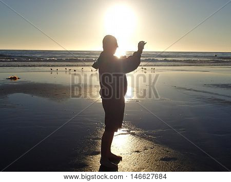 Unidentified man taking a photo at the beach
