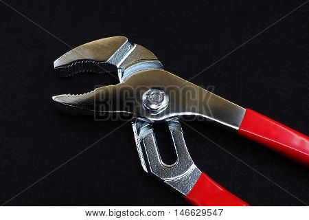pliers or wrench red handle on dark background