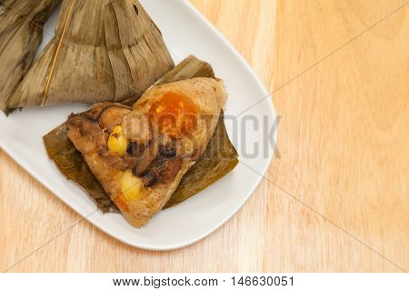 Zongzi is a traditional Chinese food made of glutinous rice stuffed with different fillings and wrapped in bamboo reed or other large flat leaves.