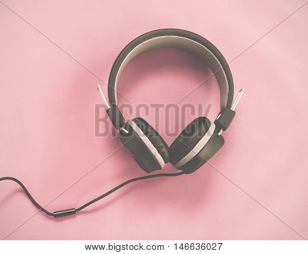 A black headphones isolated pink vintage tone.