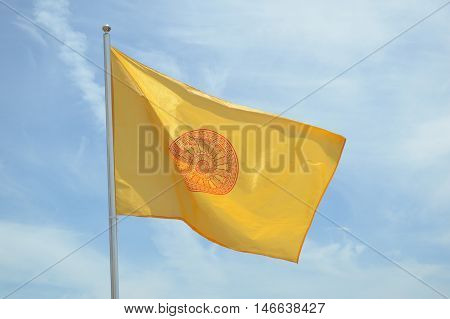 close up buddhist yellow flag on blue sky