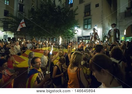BARCELONA SPAIN - SEPTEMBER 10 2016: People takes the large flag of the Catalonia region to the streets during the night eve of La Diada the Catalan National Day at Barcelona on September 10 2016.