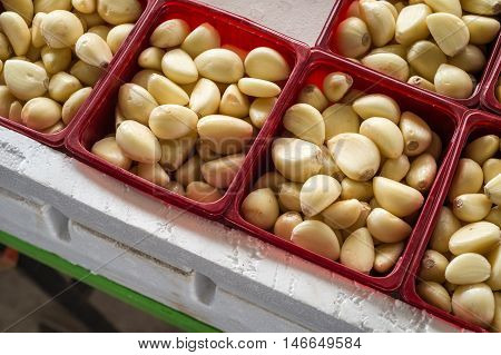 Peeled garlic cloves in boxes at the market