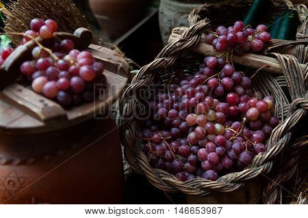 still life of grapes and rustic wicker baskets air