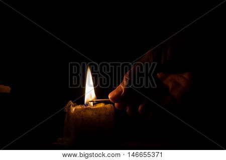 Men are using the match to light the candle