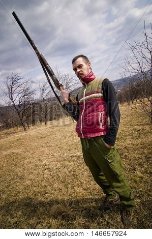 Man hunter holding rifle portrait outdoors in forest