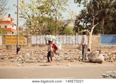 JAIPUR, INDIA - JAN 21, 2015: Unidentified poor children collect rubbish on the streets for recycling on January 21, 2015 in Rajasthan. Jaipur with population 6664000 people is a capital of Rajasthan
