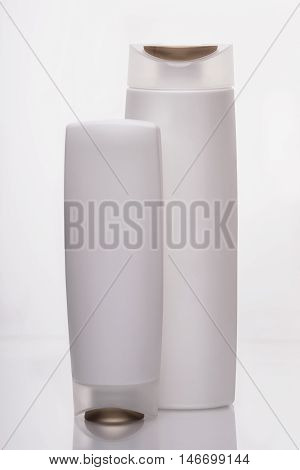White bottles for liquids and shampoo in the bathroom on a white background. Milk white color gives you a feeling of cleanliness and comfort.