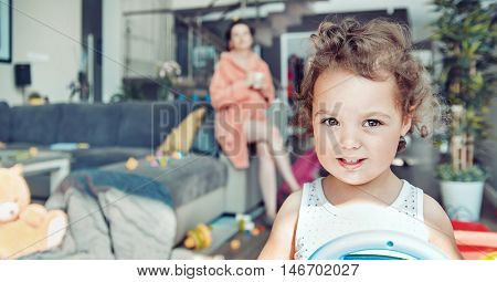 Young pregnant mother and her little daughter, at home