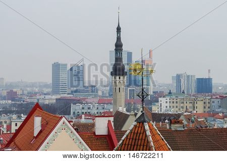 Tallinn, Estonia -March 27, 2010: Spire of town hall and roof of Tallinn old medieval city. Skyscrapers of new part of the city at background. Tallinn Estonia
