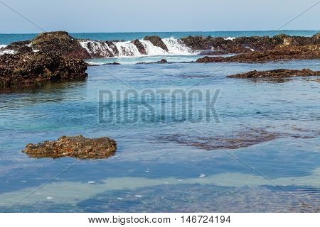 Rocky ocean coastline tidal water pools landscape.