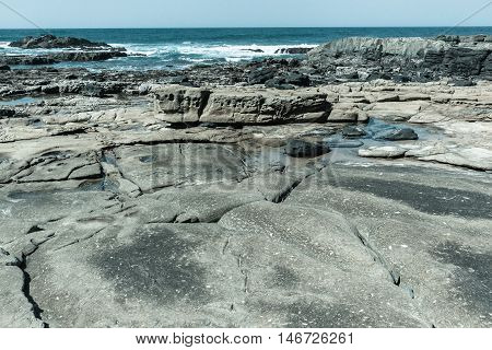 Rocky ocean coastline tidal water pools in vintage landscape.