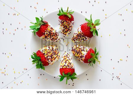 Healthy snack funny for kids fresh strawberries diped in yogurt or cream decorated with pastry decorations top view
