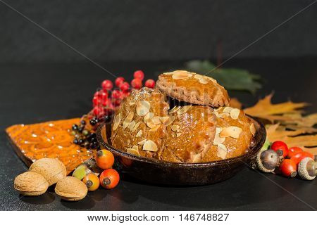 Typical Dutch filled spicy cookies with almonds on autumn colored and dark background