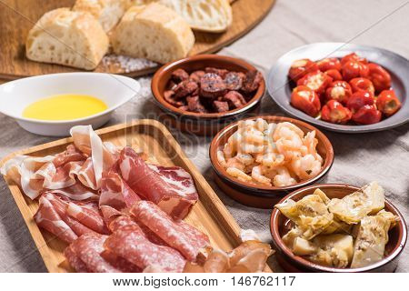 Tapas food served in small bowls cold meat goat cheese. A meal for sharing