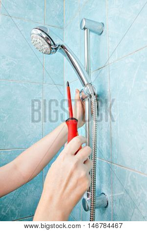 Replacing the plumbing in the bathroom close-up adjustment the adjustable bracket wall mounted hand shower and hose holder.