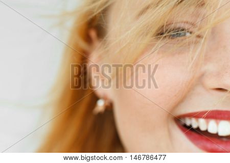 Half face of laughing red-haired woman. Close-up portrait of sunny adorable carroty girl with freckles. Blurry live dynamic photo, free space