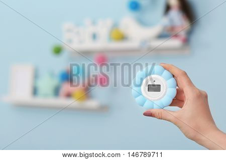 Woman checking temperature and humidity in baby room