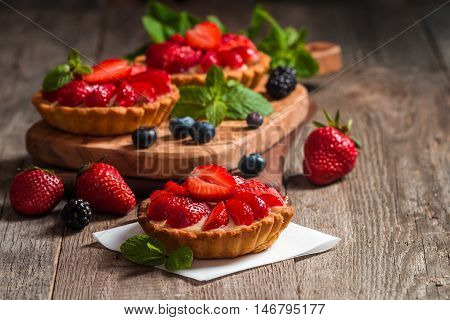 Fresh homemade strawberries tarts  on wooden background