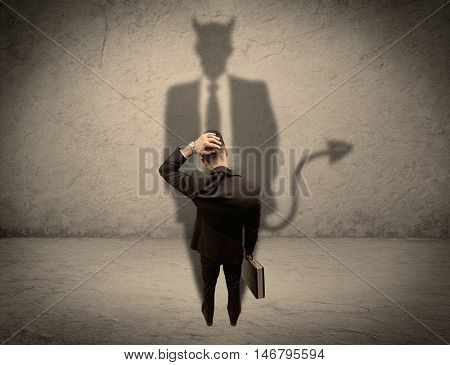 An experienced tricky businessman in suit looking at his devil desguise shadow reflected on the wall concept