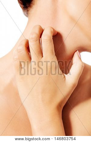 Topless woman scratching her neck.