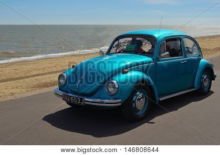 Felixstowe, Suffolk, England - May 01, 2016: Classic Blue  Volkswagen Beetle being driven along Felixstowe seafront promenade.