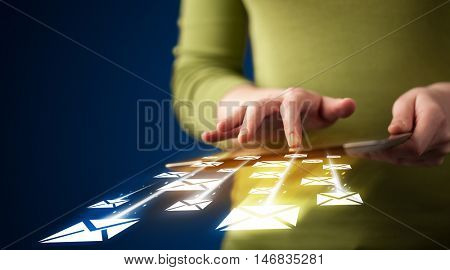 Hand holding tablet and sending email icons concept on background