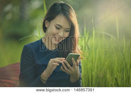 Asian woman wearing traditional dress sitting telephone.