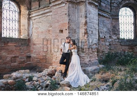 Groom and fiancee in ancient building among ruins