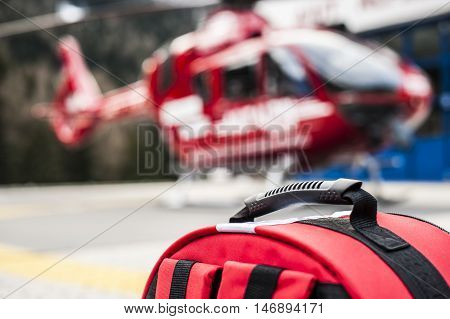 emergency rucksack with medical devices and a rescue helicopter