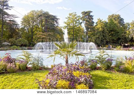 fountain in a park in Toulouse with trees and flowers