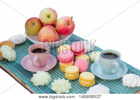 Still life of served coffee cups macaroon cookies marshmallows and apples