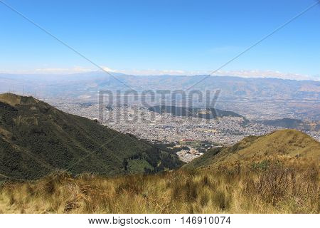 This photo shows a view of the valley of the Quito City from west to east and the Cayambe Volcano in the background at Quito, Ecuador.